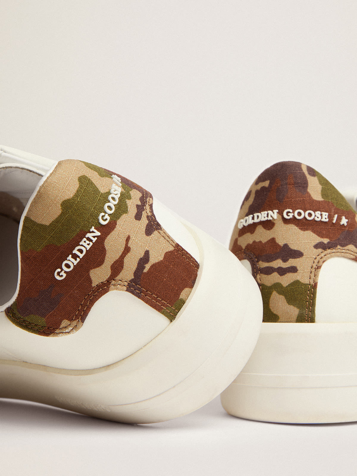 Sneaker Purestar in pelle bianca con stella ton sur ton e talloncino verde in tessuto ripstop con stampa camouflage