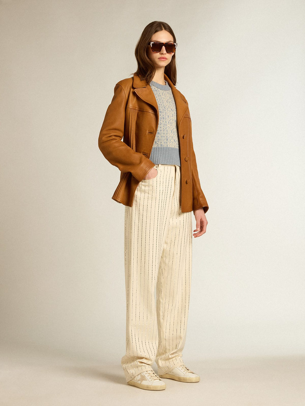 Pantalone di colore bianco con borchie a baguette applicate