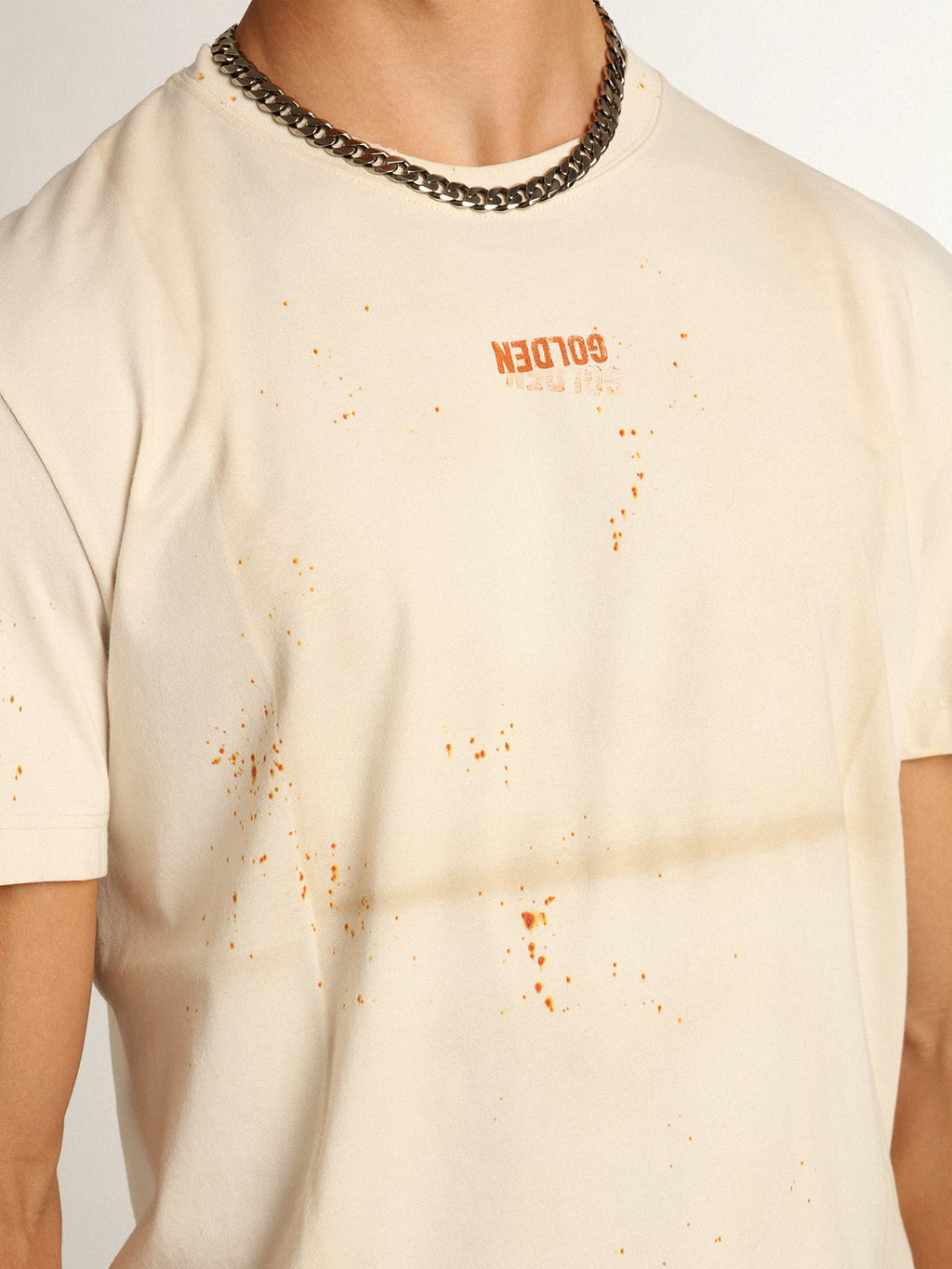 T-shirt Collezione Journey di colore bone white dall'effetto capo piegato con scritta Golden e spruzzature color ruggine