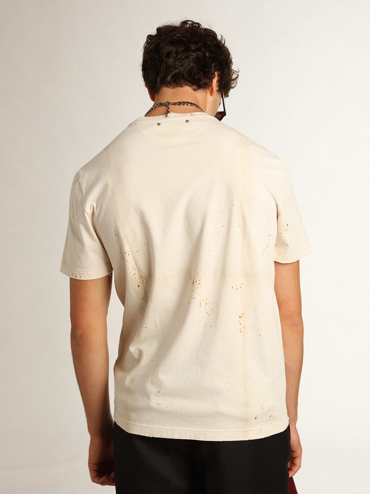 T-shirt Collezione Journey di colore bone white dall'effetto capo piegato con scritta Golden e spruzzature color ruggine