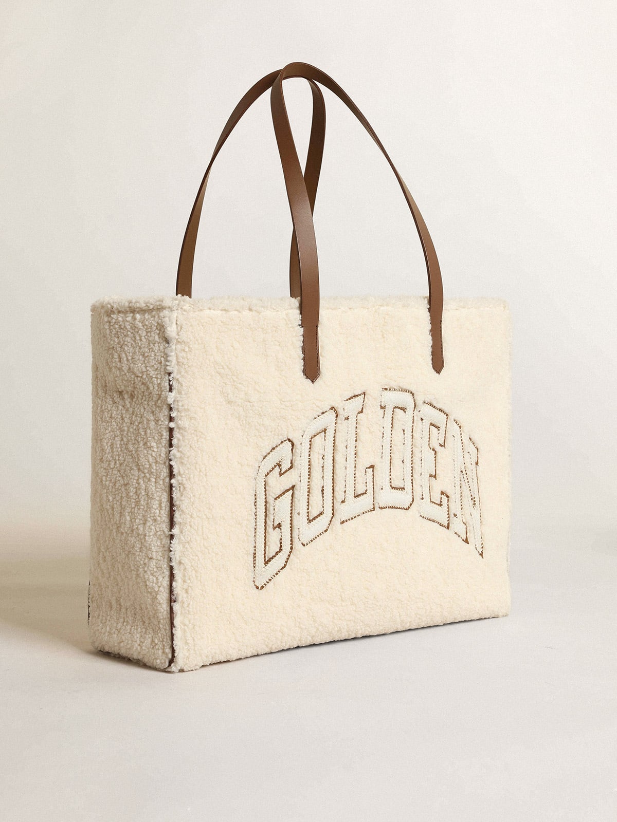 Borsa California Bag East-West in eco-pelliccia di colore bianco con scritta Golden e manici a contrasto