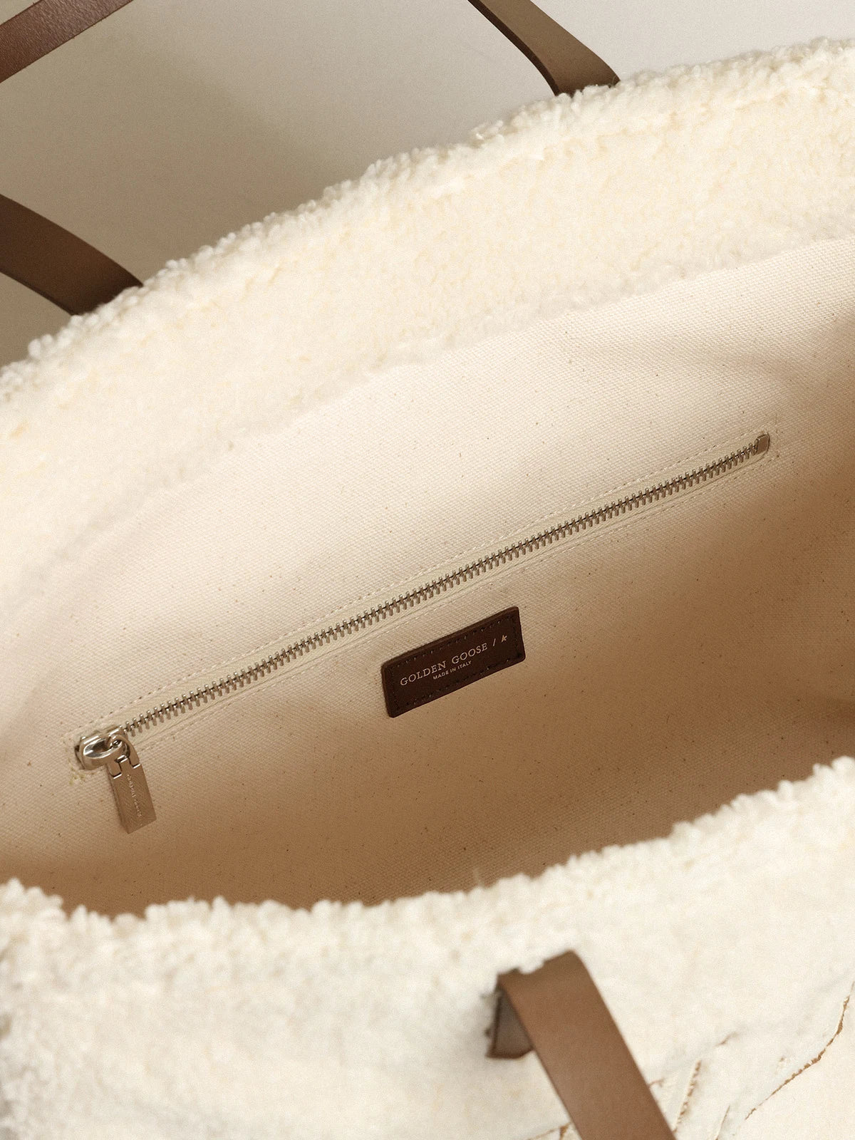 Borsa California Bag East-West in eco-pelliccia di colore bianco con scritta Golden e manici a contrasto