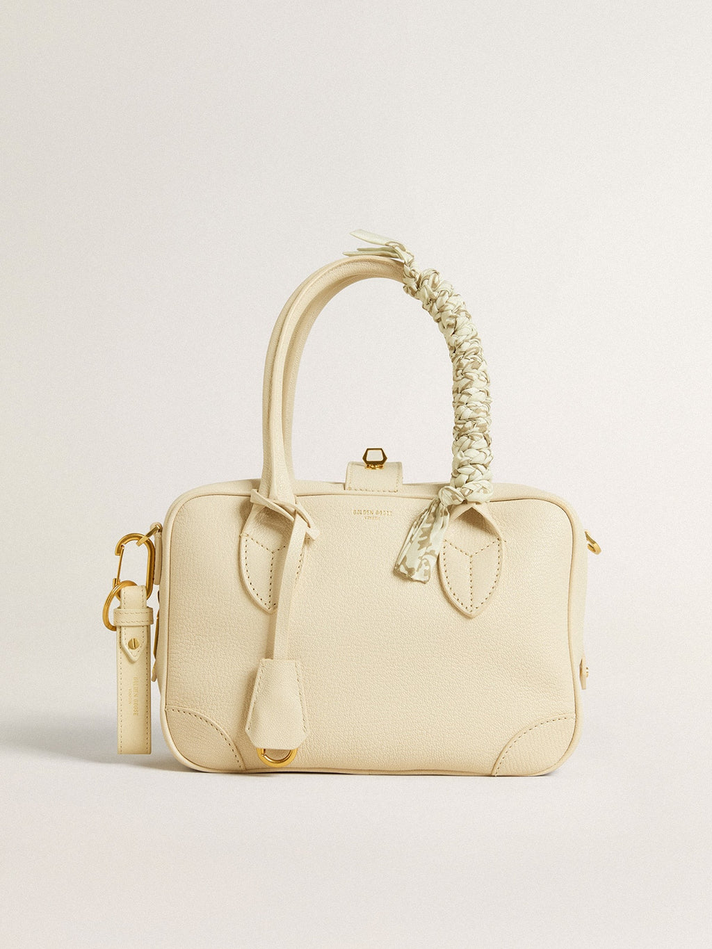 Butter-colored braided fabric charm with brass chain