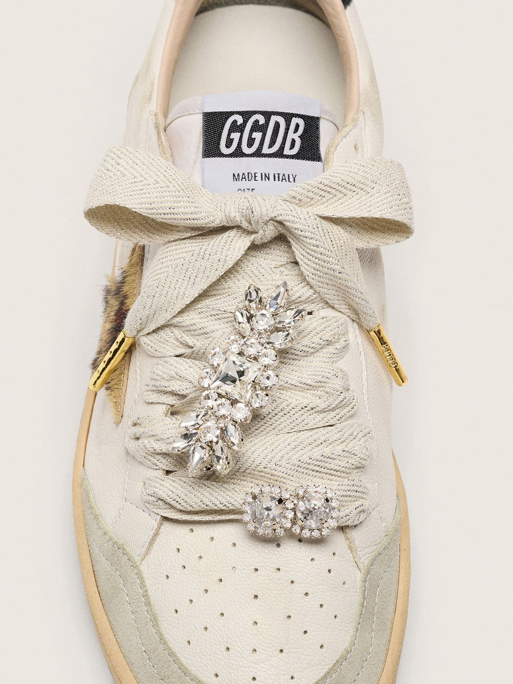 Skins "Sparkling" cream and silver herringbone laces embellished with two charms